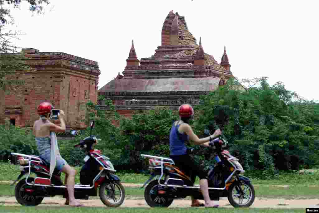 Tourists take pictures of a damaged pagoda after an earthquake in Bagan, Aug. 25, 2016.