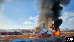 Api dan asap tampak mengepul dari bagian ekor pesawat Jeju Air Boeing 737-800 setelah pesawat tersebut jatuh saat berusaha mendarat di Bandara Internasional Muan di provinsi Jeolla Selatan, pada 29 Desember 2024. (Foto: Yonhap/AFP)