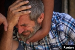 A displaced Iraqi man who fled his home reacts during a fight between Iraqi forces and Islamic State militants in the al-Zanjili neighborhood, north of the old city district of Mosul, Iraq, May 30, 2017.
