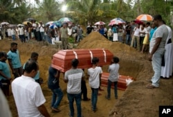 Relatives carry a coffin for burial during the funerals of three members of the same family, all died at Easter Sunday bomb blast at St. Sebastian Church in Negombo, Sri Lanka, Monday, April 22, 2019.