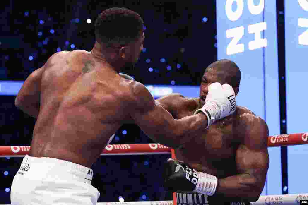 Moyi Grande-Bretagne Anthony Joshua (G) abeti likofi na moyi Grande-Bretagne mosusu Daniel Dubois na bitumba ya ba poids lourds ya molongo ya IBF na stade Wembley na Londres, sanza ya libwa 21 2024. (Photo by Adrian Dennis / AFP)
