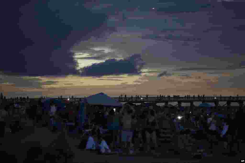 The Isle of Palms beach turns dark during the solar eclipse Monday, Aug. 21, 2017, on the beach at Isle of Palms, South Carolina.