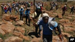 Des mineurs courent en chantant lors d'une grève à la mine Ashanti AngloGold, à Fochville près de Johannesburg, en Afrique du Sud, le 18 octobre 2012. (AP Photo/Themba Hadebe) 