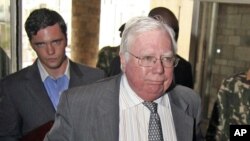 FILE - Jerome Corsi, right, arrives at the immigration department in Nairobi, Kenya, Oct. 7, 2008. Special counsel Robert Mueller's team believes Corsi tipped off a Donald Trump ally months before the release of emails stolen from Hillary Clinton's campaign chairman.