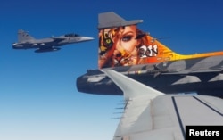 Two Czech Gripen fighter planes demonstrate a flight interception of a Belgian air force transport plane over the Czech Republic, Sept.12, 2018 as part of NATO drills.