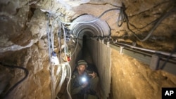 An Israeli army officer shows journalists a tunnel allegedly used by Palestinian militants for cross-border attacks from Gaza into Israel, July 25, 2014.
