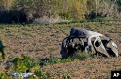 The wreckage of the car of investigative journalist Daphne Caruana Galizia lies next to a road in the town of Mosta, Malta, Oct. 16, 2017.