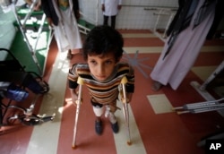 FILE - A young boy who lost his leg in the Yemen war uses a prosthetic limb at a government-run rehabilitation center in Sana'a, Yemen, Saturday, March 5, 2016.