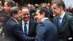 Turkish Prime Minister Ahmet Davutoglu, left, speaks with, from left, French President Francois Hollande, Greek Prime Minister Alexis Tsipras and Estonian Prime Minister Taavi Roivas during a round table meeting at an EU summit in Brussels, March 18, 2016