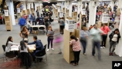 FILE - Election workers and voters move about the main polling station in Bogota, Colombia, March 11, 2018.