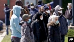FILE - People line up for a free COVID-19 test in a parking lot in Milwaukee, Wisconsin, May 11, 2020. 
