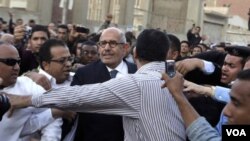 Mohamed ElBaradei (tengah) meninggalkan sebuah TPS referendum di Kairo, Sabtu (19/3). Tokoh oposisi menentang amandemen UUD tentang pemilu.