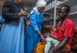 FILE - A health worker prepares to vaccinate a child against malaria, at Mitundu Community Hospital, in Malawi's capital of Lilongwe, April 23, 2019.
