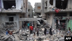 Warga Palestina memeriksa kerusakan dan puing-puing sehari setelah operasi Pasukan Khusus Israel di kamp Nuseirat, di Jalur Gaza tengah pada 9 Juni 2024, di tengah konflik antara Israel dan kelompok militan Hamas Palestina.