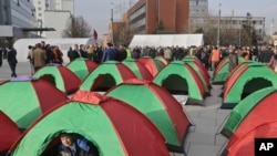 A child plays inside a tent set up by Kosovo opposition supporters in front of the main governing building in Kosovo's capital Pristina, Feb. 23, 2016.
