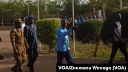 Le ministre du Burkina Faso, de la sécurité, Simon Compaoré, à droite, accompagné du chef d'état-major, le général Pingrenoma Zagré, visite le site d'une attaque contre un poste de police dans le village d'Intagom, 5 km de la frontière avec le Mali, 1er juin 2016. (VOA /ZoumanaWonogo)