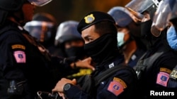 មន្ត្រីប៉ូលិសថៃកំពុងឃ្លាំមើលបាតុករក្នុងអំឡុងពេលក្រុមបាតុករថៃដែលគាំទ្រលទ្ធិប្រជាធិបតេយ្យនាំគ្នាធ្វើបាតុកម្មប្រឆាំងរដ្ឋាភិបាលនិងរបបរាជានិយម ក្នុងទីក្រុងបាងកក ប្រទេសថៃ ថ្ងៃទី១៦ ខែមករា ឆ្នាំ២០២១។ 