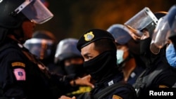 A police officer stands guard during a demonstration demanding to release the people arrested following the anti-government and reforming monarchy protests in Bangkok, Thailand, Jan. 16, 2021.