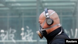 Seorang pria menggunakan masker di jalanan Beijing akibat pencemaran udara yang parah, Mei 2013. (Foto: Dok)