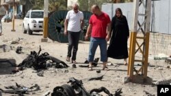 Waga melewati lokasi serangan bom mobil di Baghdad (25/6). (AP/Hadi Mizban)