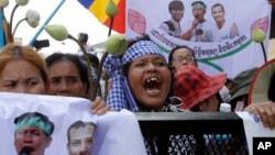 Supporters shout slogans on a blocked main street near the Phnom Penh Municipality Court during their gathering to call for the release of anti-governments protesters who were arrested in a police crackdown, in Phnom Penh, file photo. 