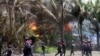Policemen walk towards burning buildings in Sittwe, capital of Rakhine state in western Burma, where sectarian violence is ongoing, June 12, 2012. 