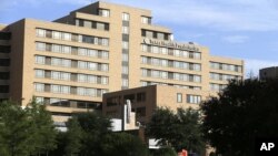 Pedestrians walk outside Texas Health Presbyterian Hospital in Dallas, Sept. 30, 2014. 