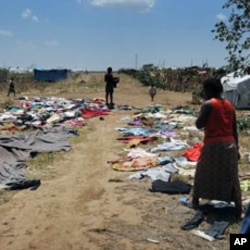 Residents of Vumilia Eldoret Camp dry out clothes after a rainstorm destroyed their tent
