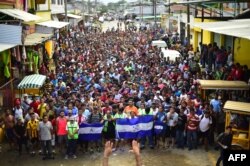 Honduran migrants heading in a caravan to the US, hold a demonstration demanding authorities to allow the rest of the group to cross, in Ciudad Hidalgo, Chiapas state, Mexico after crossing from Guatemala, Oct. 20, 2018.