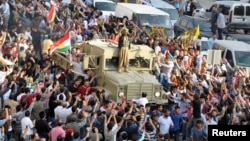 Convoy of peshmerga vehicles is escorted by Turkish Kurds on their way to the Turkish-Syrian border, in Kiziltepe, near the southeastern city of Mardin, Oct. 29, 2014.