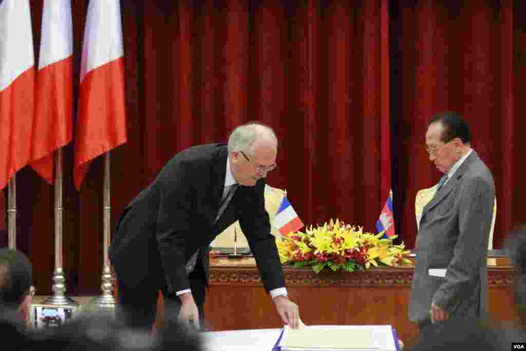 លោក ​អាឡាំង ហ្វុកតាំង​ និង​លោក ហោ ណាំ​ហុង​ នៅ​ក្នុង​ពិធី​ប្រគល់​ ទទួល​ និង​ផ្ទៀង​ផ្ទាត់​ផែន​ទី​ ពីស្ថានទូតបារាំង​ នៅ​វិមាន​សន្តិភាព​ កាល​ពី​ថ្ងៃ​ទី០៣​ ខែ​កញ្ញា​ ឆ្នាំ​២០១៥។ (ហ៊ាន​ សុជាតា/VOA)