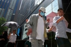 Businessman Cheung Chi-tai, center, accompanied by his body guard, leaves Wanchai District Court after a hearing for his upcoming money laundering trial, in Hong Kong, Oct. 14, 2016.