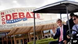 Sen. John Kerry, D-Mass., left, waves as he rides in a golf cart after giving an interview in front of the debate hall ahead of the presidential debate between Republican presidential candidate, former Massachusetts Gov. Mitt Romney and President Barack O