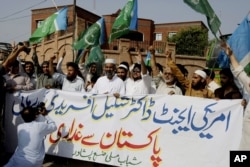 Supporters of Pakistani religious party Jamaat-e-Islami rally holding a banner reads "Release of American agent doctor Shakil Afridi is betrayal from Pakistan," in Peshawar, Pakistan, Friday, Aug. 30, 2013.