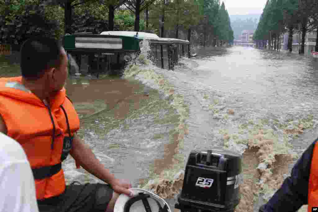 Perahu melewati jalanan yang terendam banjir di Anju City, provinsi Phyongan Barat, Korea Utara (30/7). 