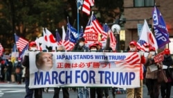 Supporters of U.S. President Donald Trump hold a banner as they march ahead of the inauguration of President-elect Joe Biden, amid the coronavirus disease (COVID-19) outbreak, at Ginza district in Tokyo, Japan January 20, 2021. REUTERS/Issei Kato