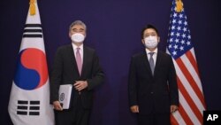 FILE - U.S. special representative for North Korea Sung Kim, left, and South Korea's Special Representative for Korean Peninsula Peace and Security Affairs Noh Kyu-duk pose for a photo during their bilateral meeting at a hotel in Seoul, June 21, 2021.