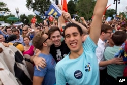 Supporters of same-sex marriage celebrate outside of the Supreme Court in Washington, Friday June 26, 2015, after the court declared that same-sex couples have a right to marry anywhere in the US.