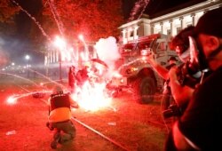 Flares go off in front of a Kenosha Country Sheriff vehicle as demonstrators take part in a protest following the police shooting of Jacob Blake, a Black man, in Kenosha, Wisconsin, Aug. 25, 2020.