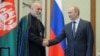 Russian President Vladimir Putin (R) and Afghan President Hamid Karzai shake hands during a meeting in Beijing, China, June 7, 2012. 