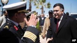 This image released by the media office of the unity government shows Fayez al-Saraj, right, upon his arrival in Tripoli, Libya, March 30, 2016.