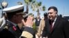 FILE - This image released by the media office of the unity government shows Fayez al-Sarraj, right, upon his arrival in Tripoli, Libya, March 30, 2016. He arrived by sea with six deputies to set up a temporary seat of power in a naval base.