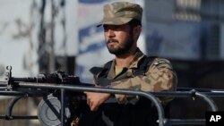 FILE - A Pakistan army soldier mans at a vehicle during a curfew in Rawalpindi, Pakistan on Saturday, Nov. 16, 2013.