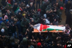 Palestinians carry the body of Saad al-Atrash to a hospital in the West Bank city of Hebron, Jan.1, 2016. The Israeli military transferred 23 bodies of Palestinians it says were involved in violence to their families in the West Bank.