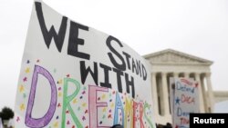 FILE - Demonstrators rally outside the Supreme Court as justices were scheduled to hear arguments in the consolidation of three cases regarding the Trump administration’s bid to end DACA, in Washington, Nov. 12, 2019.