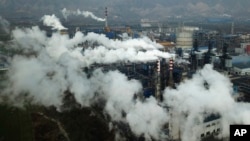 FILE - In this Nov. 28, 2019 photo, smoke and steam rise from a coal processing plant in Hejin in central China's Shanxi Province.