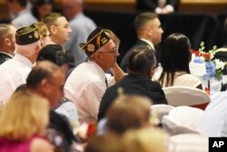 Veterans listen as President Donald Trump thanks them for their service during his remarks at a Salute to Service dinner in White Sulphur Springs, West Virginia, July 3, 2018.