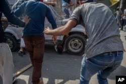 Kashmiri Protesters gather around a paramilitary vehicle as it runs over a man during a protest in Srinagar, Indian controlled Kashmir, June 1, 2018. Three people were injured, one of them seriously, after they were hit and run over by the vehicle.