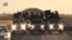 FILE - An image grab taken from a different video, released by the Islamic State group's official Al-Raqqa site via YouTube, allegedly shows IS recruits riding in trucks in an unknown location. 