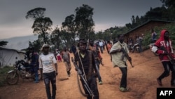 FILE - Militiamen, including alleged children, of an armed group from the Lendu community stand guard in Ituri Province, Democratic Republic of Congo, Sept. 19, 2020.